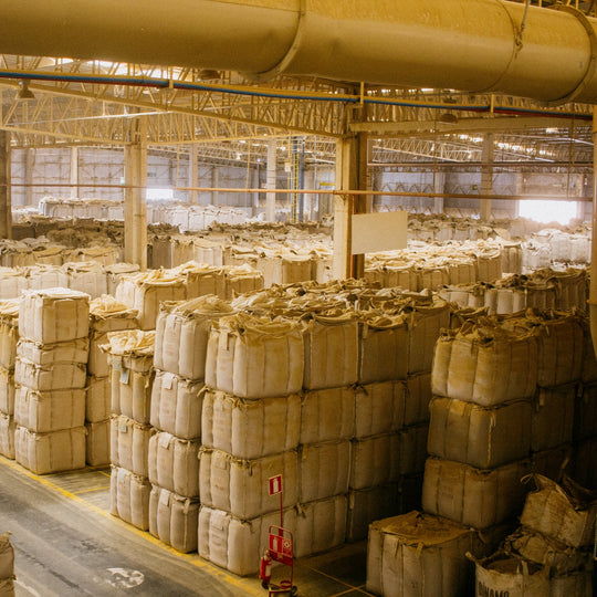 Large warehouse with stacks of cardboard boxes and materials.