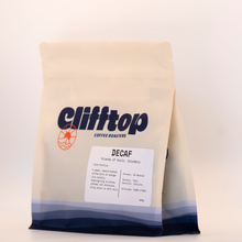 Load image into Gallery viewer, A 250g bag of Clifftop Coffee Decaf coffee from Colombia, featuring a cream-colored stand-up pouch with a navy blue logo and a white label detailing the product information.
